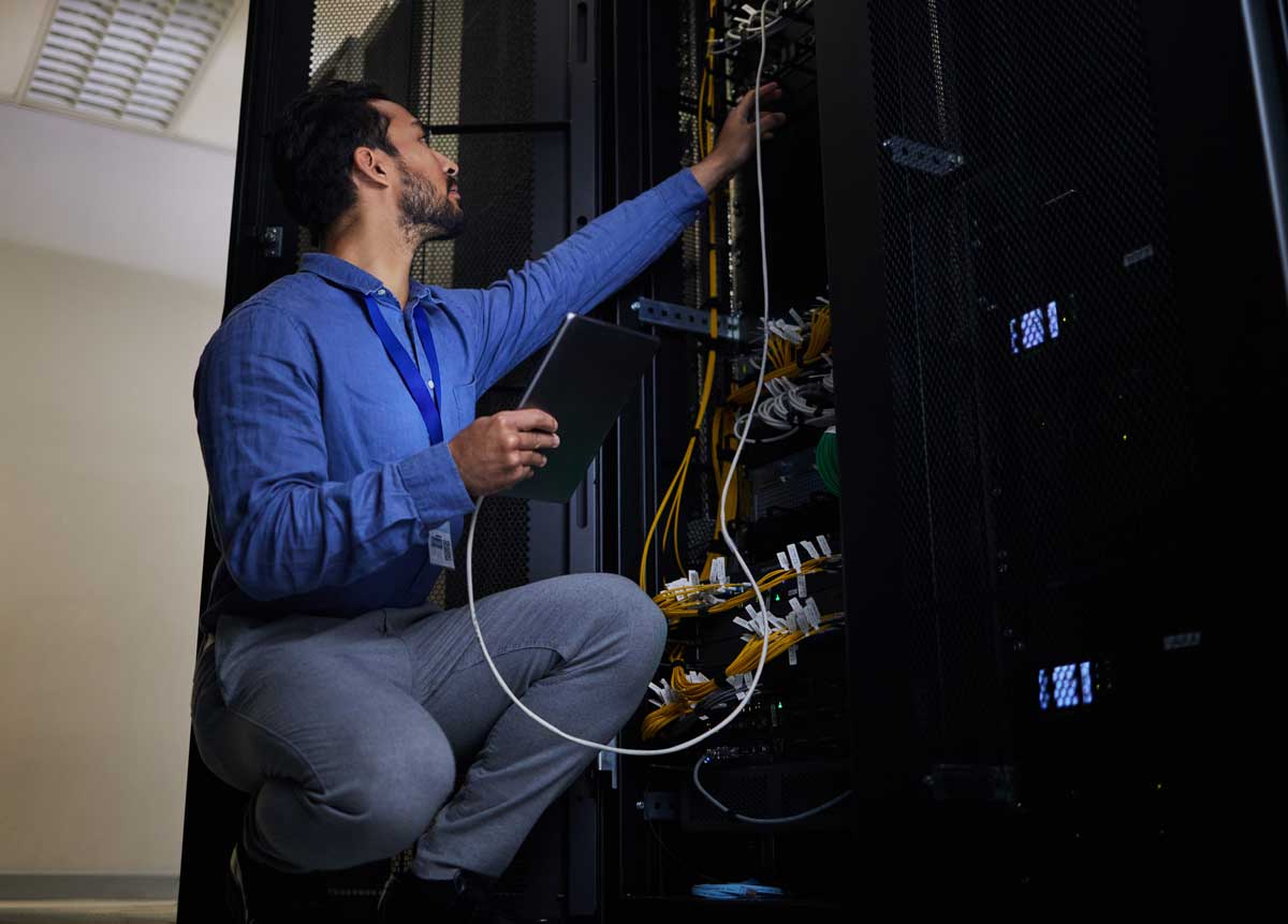 Tablet, server room and engineer with connection cable for maintenance or software update at night. Cybersecurity wire, programmer and it man holding technology for database networking in data center